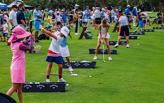 Line of young golfers practicing at First Tee event