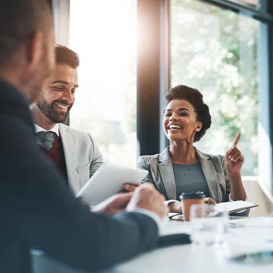 People smiling and laughing in business meeting