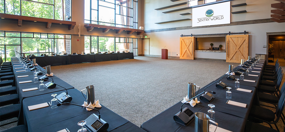 Tables set in the Atrium at SentryWorld for a corporate meeting