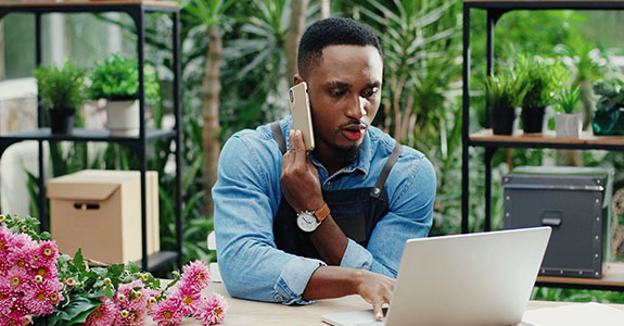 Person on mobile phone and on laptop