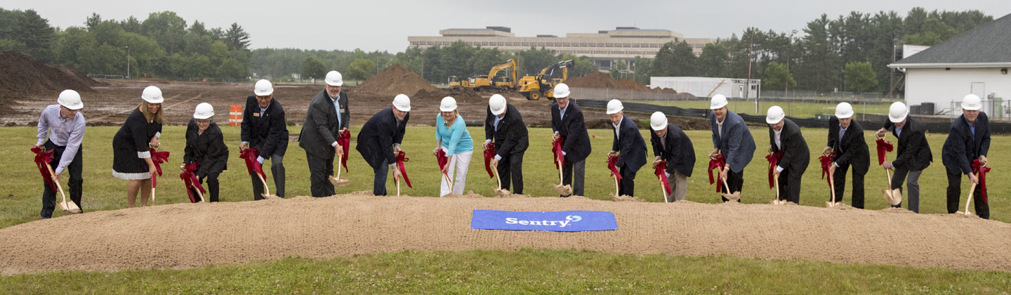 Group of people doing a ceremonial groundbreaking for new Sentry building