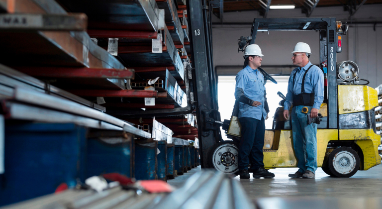 Two warehouse workers talking to each other.