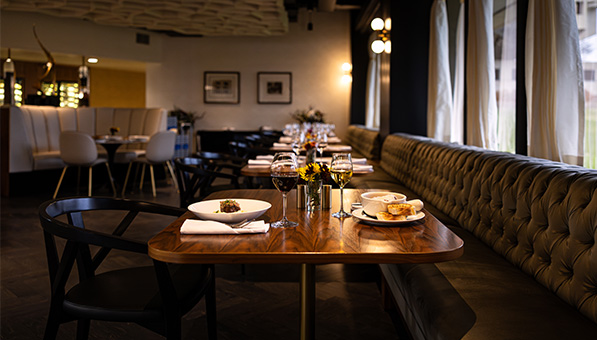 Muse dining area with plates of food and wine served.