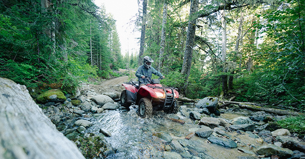 Rider navigating an ATV through rough terrain