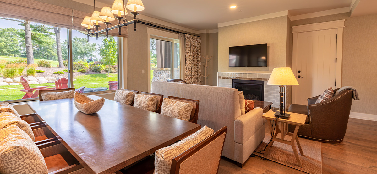 carousel-accessible-golf-view-king-suite-6-1200x556 Suite parlor room with dining room table and seating area.