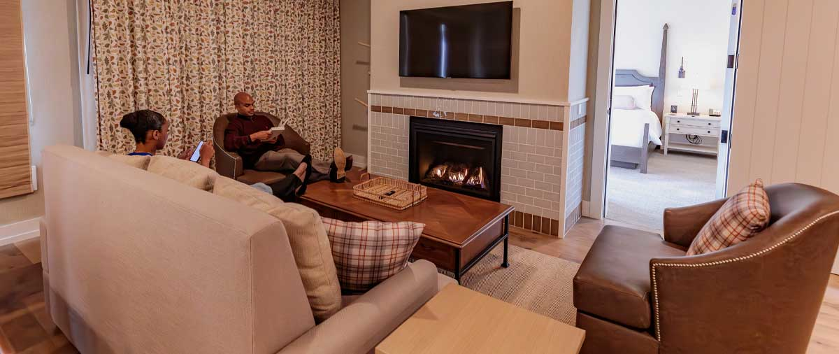 Two guests using the lounge area in their suite at The Inn