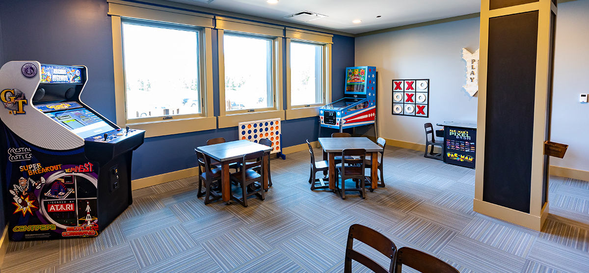 carousel-amenities-kids-club-2-1200x556 The Inn kids club with arcade games and tables.