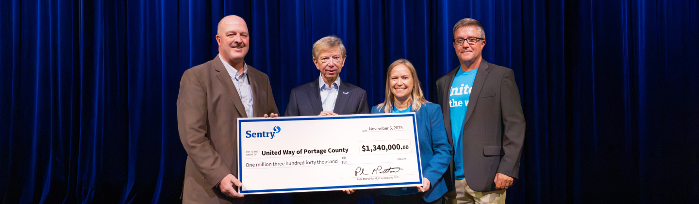 people holding a check on stage
