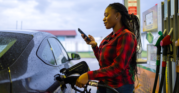 Woman on phone pumping gas into car