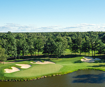 Aerial view of a green next to a water hazard at the SentryWorld golf course