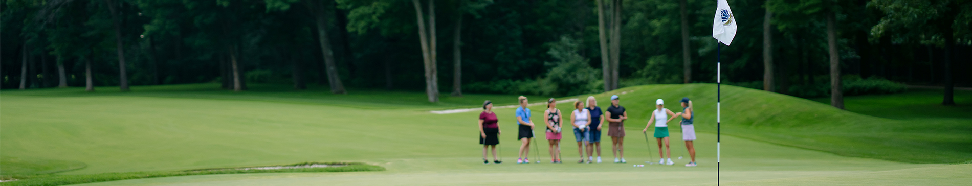 Group of women during a golf lesson standing on a green and listening