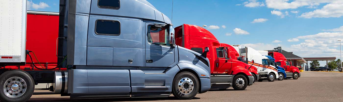 Trailer trucks parked under blue sky