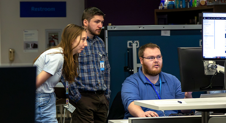 Three co-op students working on a project at the Stevens Point Sentry co-op location.