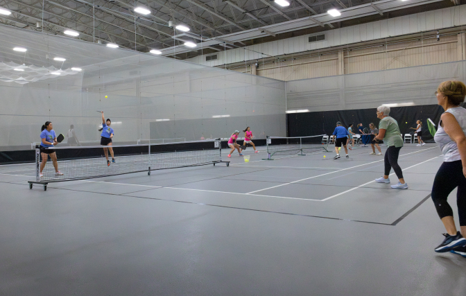 SentryWorld fieldhouse with multiple pickleball games being played. 