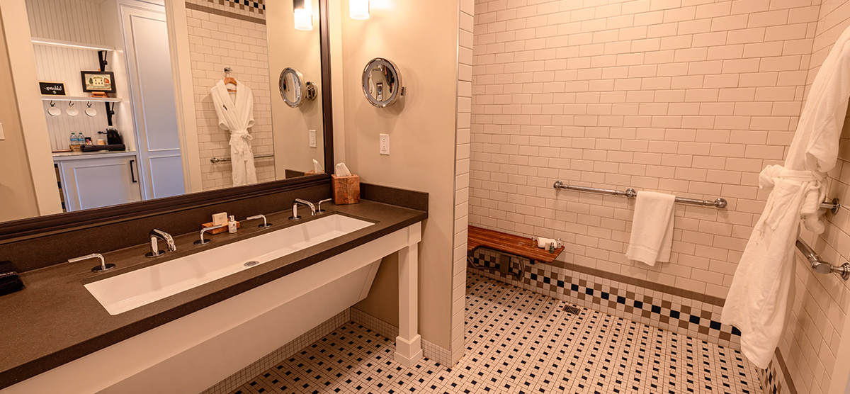 carousel-accessible-king-terrace-3-1200x556 Bathroom sink with wheelchair space and shower with grab bars.