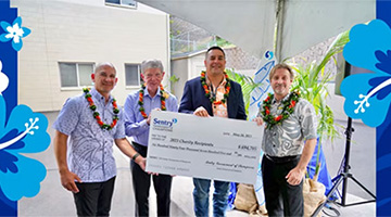 Sentry representatives and PGA tournament officials pose with a donation check for Maui non-profits