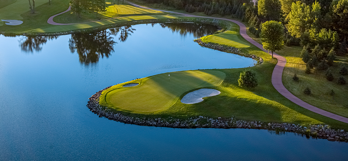 Twelfth hole putting green surrounded by a water hazard at SentryWorld