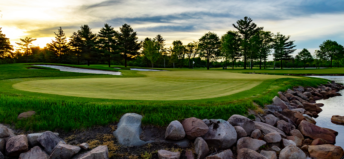 Fourth hole putting green next to a water hazard at the SentryWorld golf course