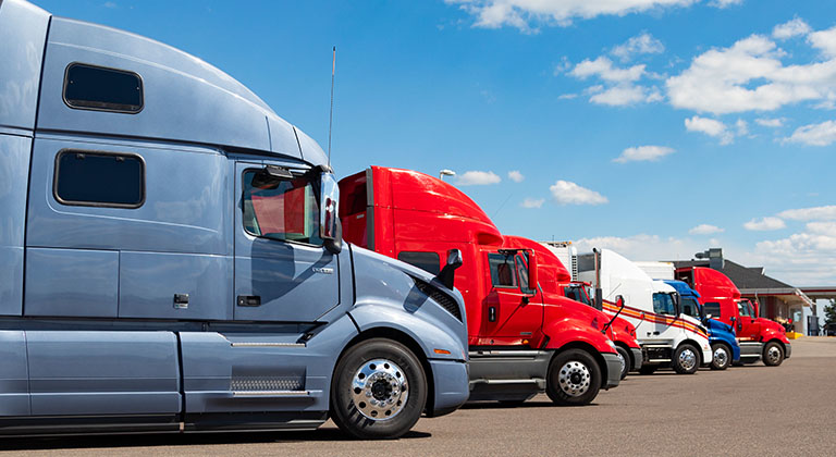 Trailer trucks parked under blue sky