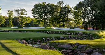 Water hazard and sand traps next to a putting green at the SentryWorld golf course