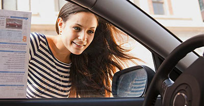 Woman looking in the window of a new vehicle
