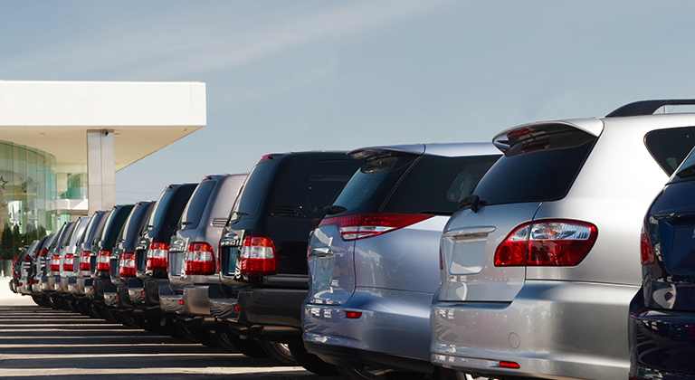 New cars parked in line at dealership