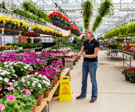 Woman with clipboard inspecting flowers