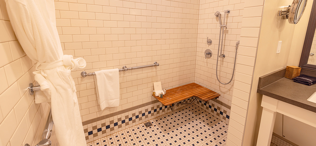 carousel-accessible-queen-terrace-4-1200x556 Shower area with bench and grab bars.