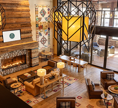 image-card-contact-inn-396x364 Overhead view of The Inn lobby with a fireplace, comfortable seating, and large light fixtures.
