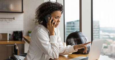 Woman talking on phone while using computer