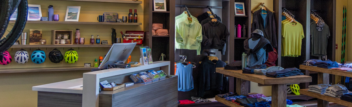 Interior of the outfitter at The Inn with clothing displays, shelves of merchandise, and a checkout counter.