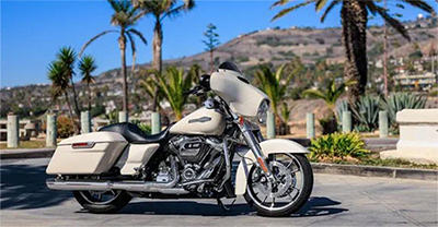 White Harley-Davidson motorcycle parked near palm trees