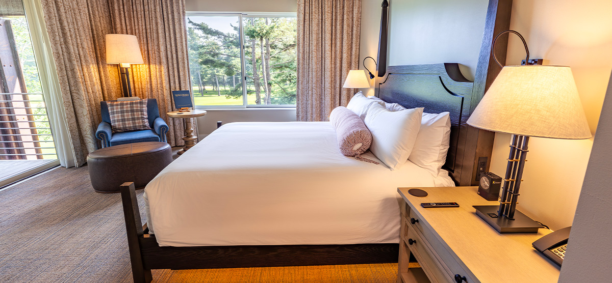 carousel-executive-golf-view-king-terrace-1-1200x556 King bed with chair and ottoman.