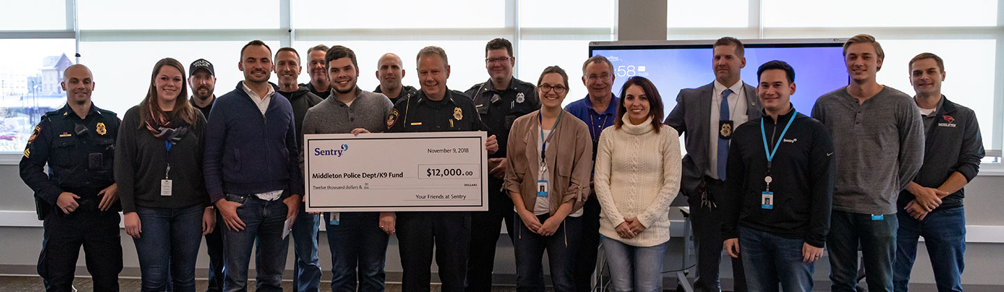 People with a check from Sentry for $12,000 for the Middleton Police Department K9 fund.