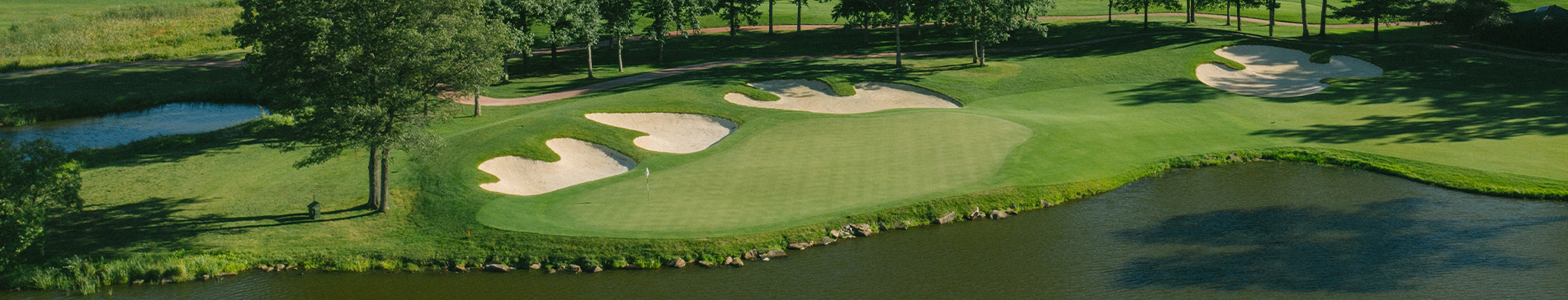 Aerial view of a putting green surrounded by sand traps and a water hazard at SentryWorld