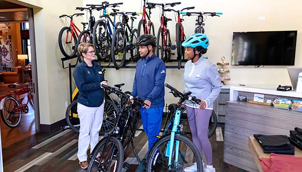 Two getting help from an employee to rent bikes in the Outfitter