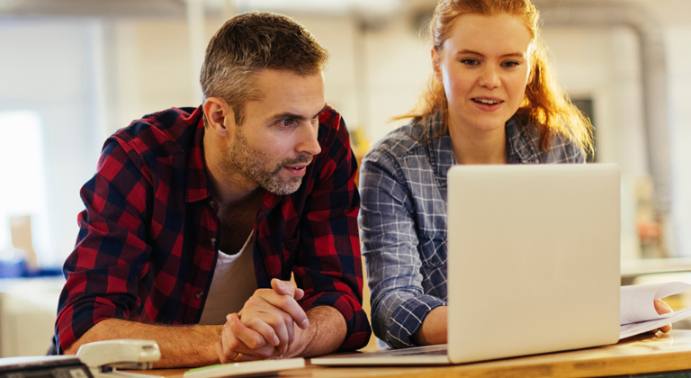 Man and woman looking at laptop at home