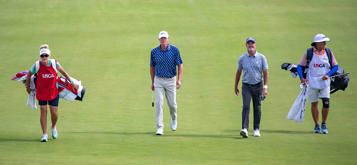 Steve Stricker and Jerry Kelly walking the SentryWorld course with their caddies