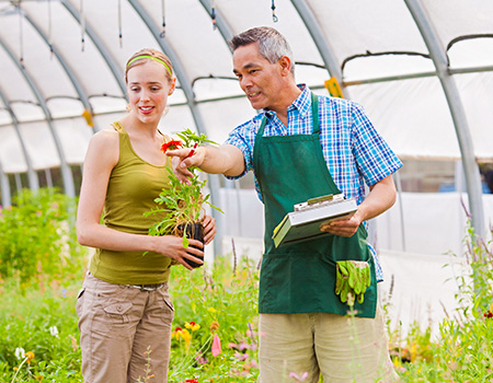 A man and a woman talking in a greenhouse