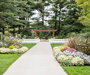 Chairs and flowers along the aisle leading to the outdoor pergola at SentryWorld