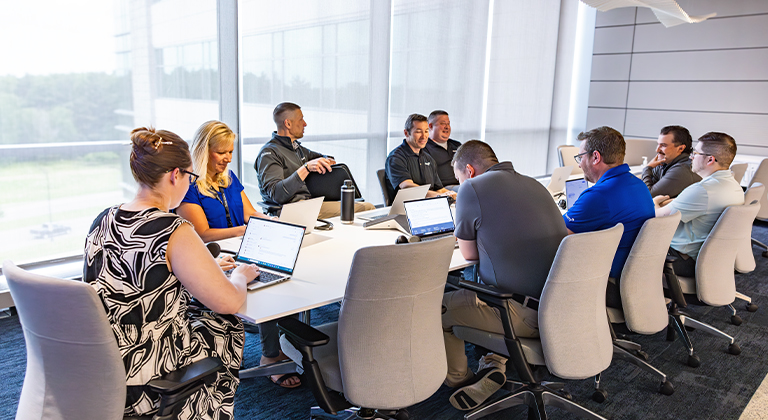group of people working together at a table in an office setting