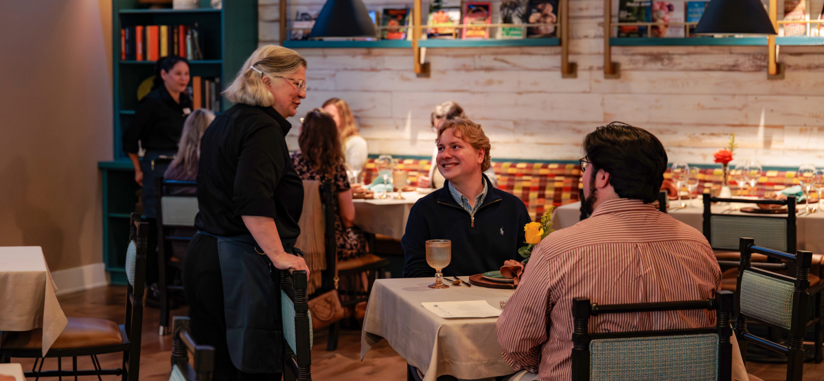 carousel-library-dinner-5-1200x556 Guests talk with waitress at The Library.