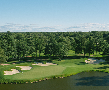 Aerial view of sand traps and a water hazard next to a putting green at SentryWorld