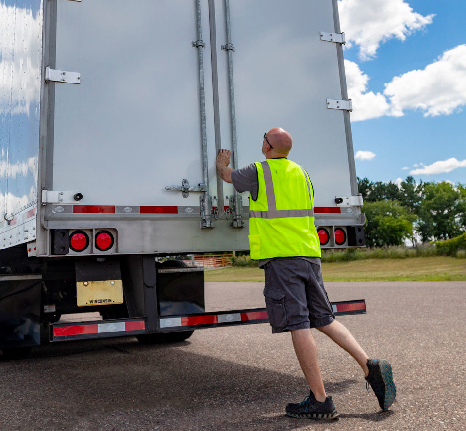 Driver checking over his semitruck before a trip.