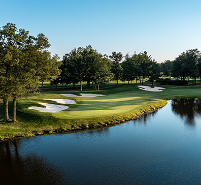 Putting green next to a water hazard and sand traps on the SentryWorld golf course