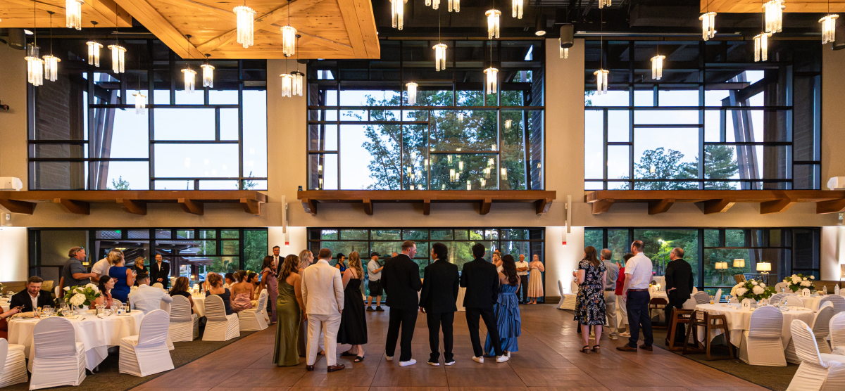 People gather in the large SentryWorld atrium with high ceilings, big windows, and set tables.