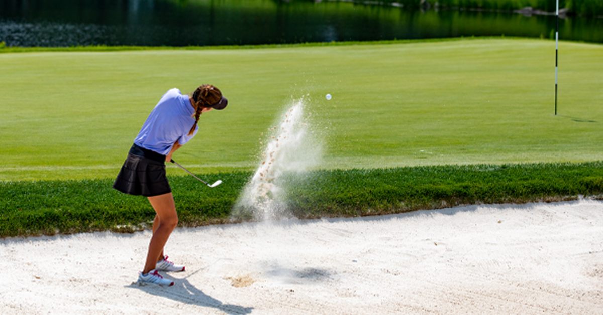 Golfer hitting out of a sand trap at the SentryWorld golf course