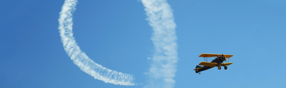 propellant plane flying with a loop of smoke in trail