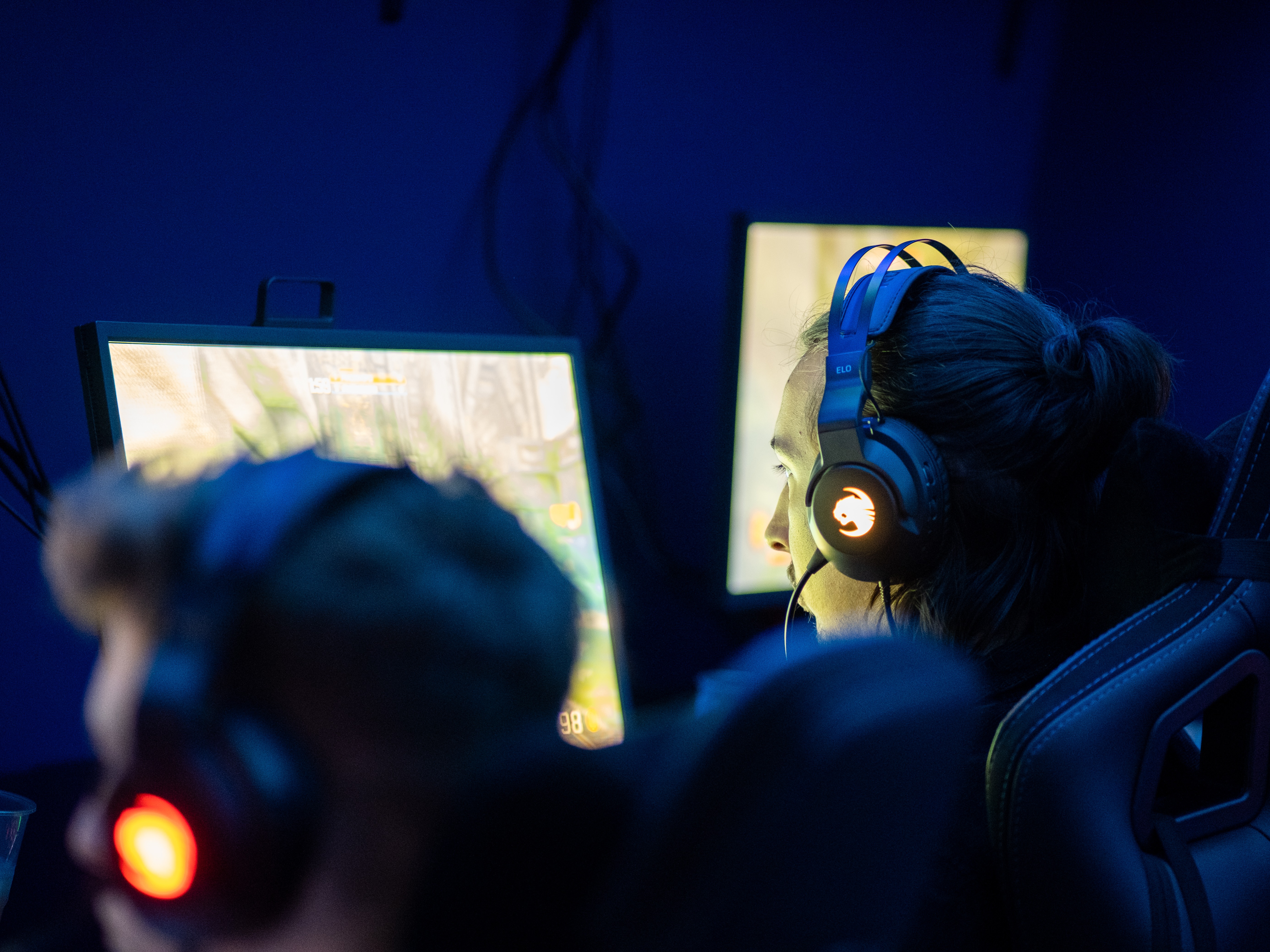 A player in a headset concentrating at a bootcamp monitor
