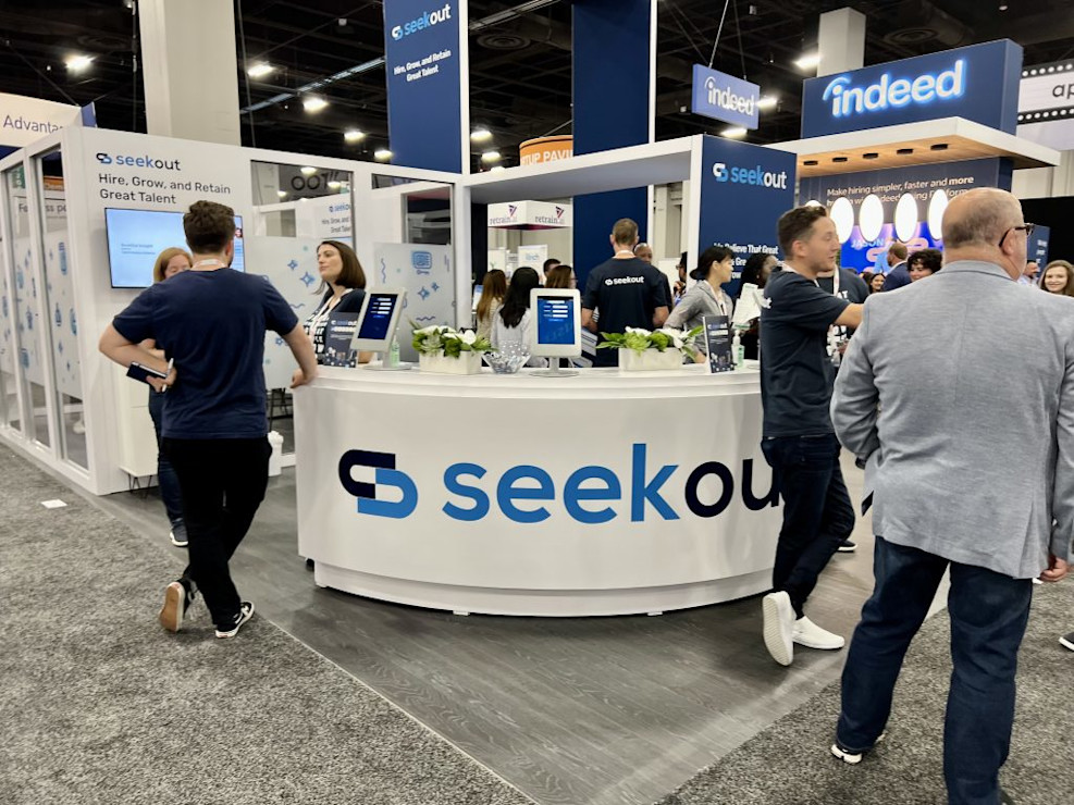 Crowd gathered at the SeekOut booth at a conference.